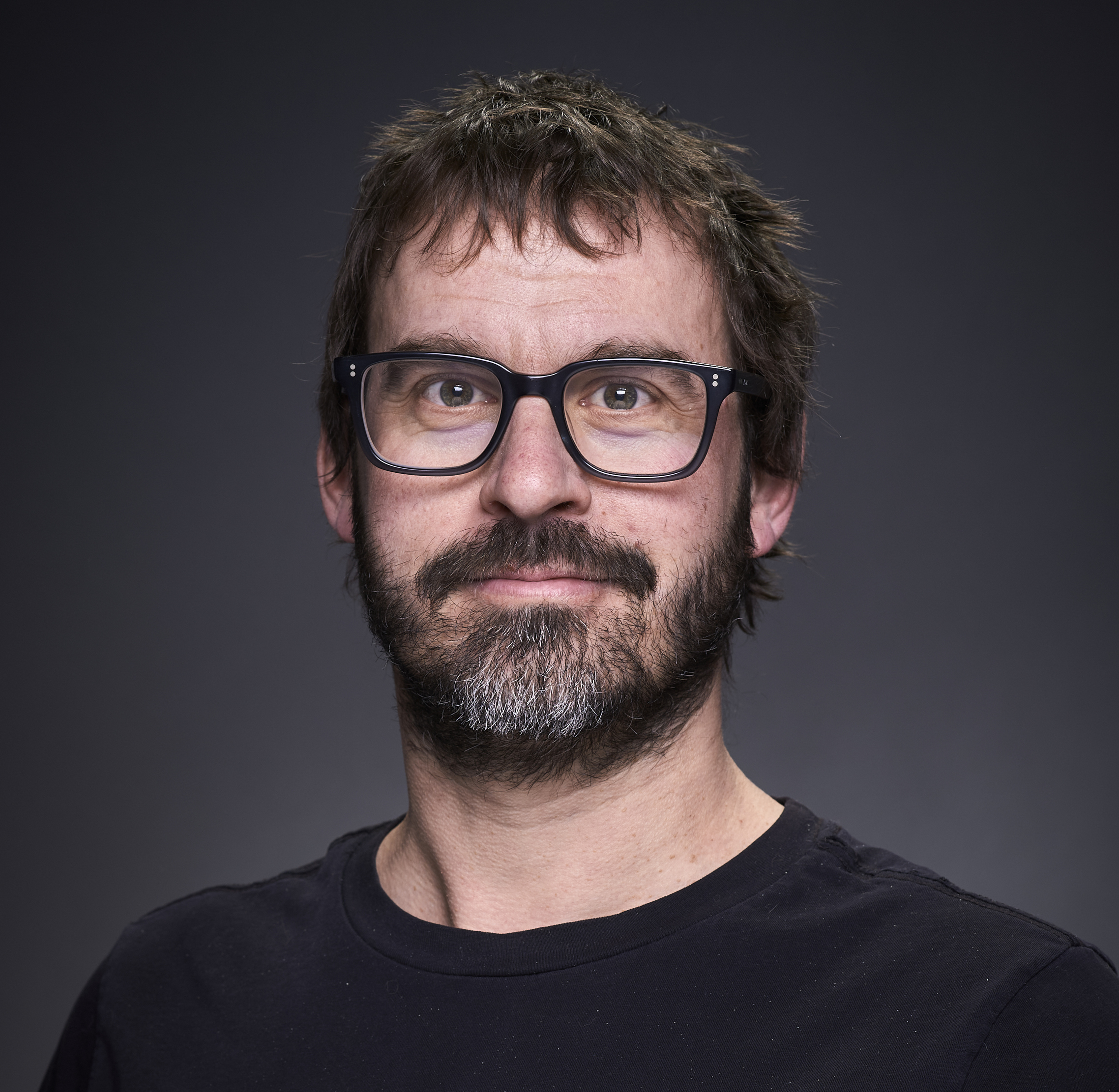 photo of a man with a beard wearing glasses 