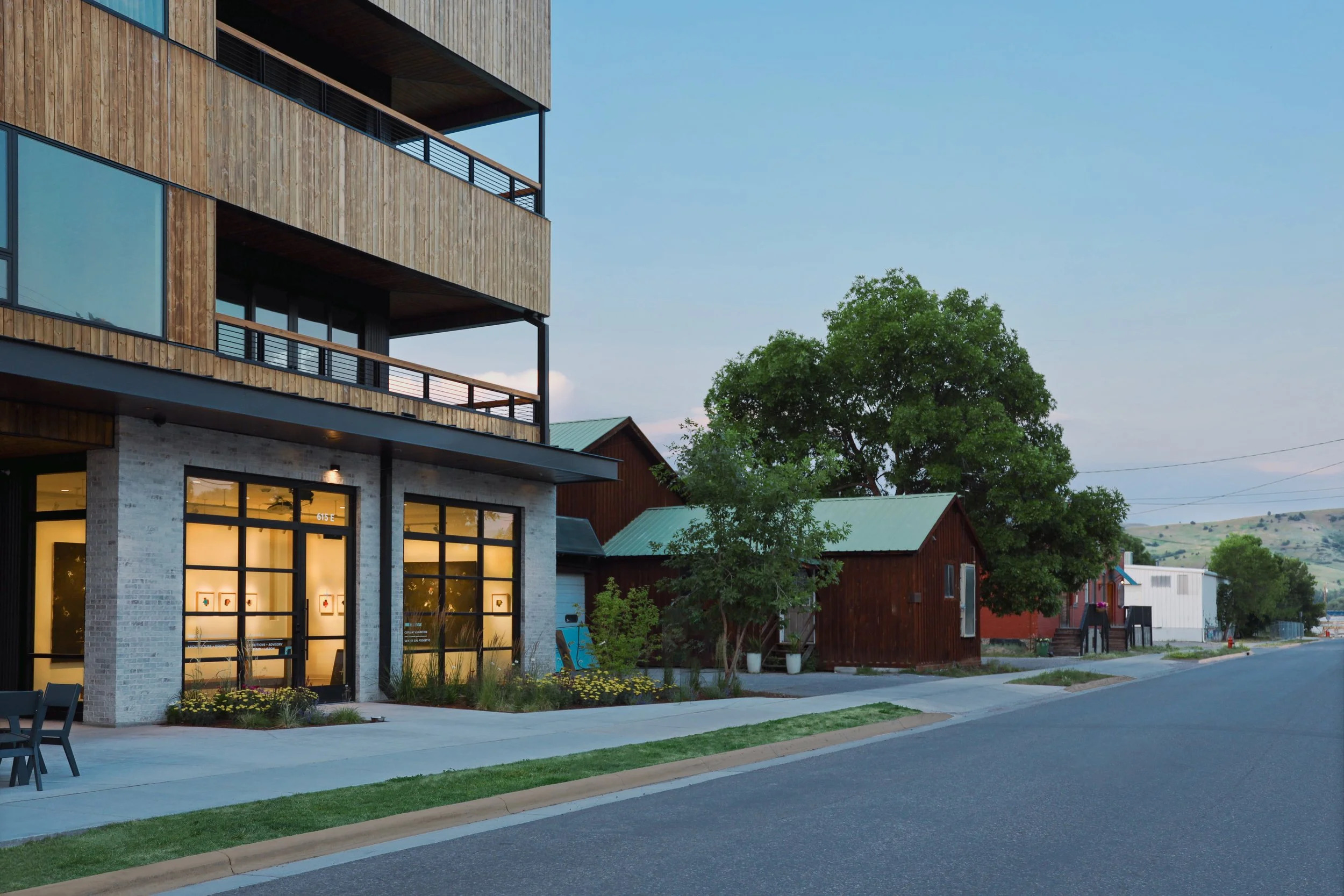 The outside of a modern looking three story building with light wood paneling